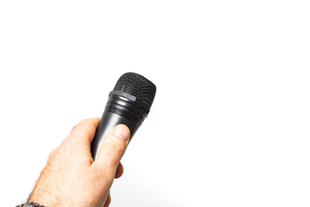 male hand holding a black microphone, isolated on white background - Fotoğraf, Görsel