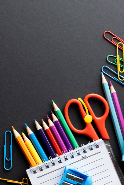 Close up of coloured pencils and school materials with copy space on black background. School materials, writing, colouring, drawing, learning, school and education concept. - 写真・画像