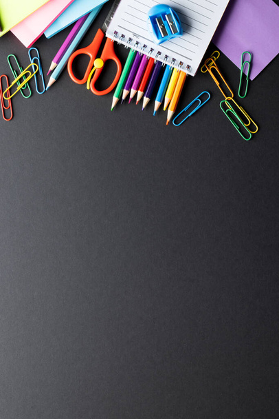 Close up of multi coloured pencils and school materials with copy space on grey background. Writing, colouring, learning, school and education concept. - Fotó, kép