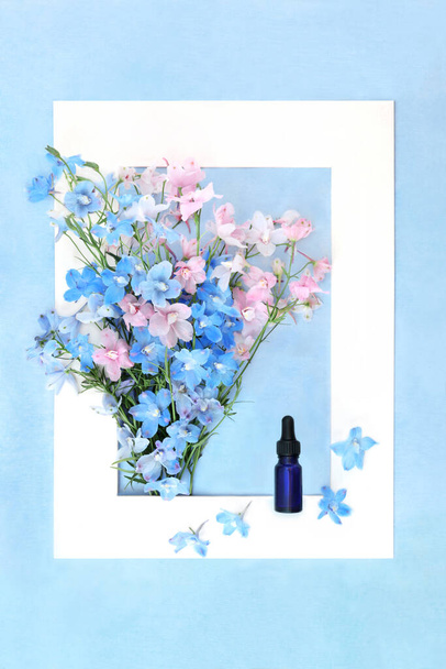 Δελφίνιο αγριολούλουδο ομοιοπαθητικό φυτικό φάρμακο με μπουκάλι βάμμα. Καλοκαιρινή χλωρίδα φύση λουλούδι σύνθεση θεραπεία. Χρησιμοποιείται ως ηρεμιστικό και για κακή όρεξη. Λευκό πλαίσιο σε μπλε κηλίδες - Φωτογραφία, εικόνα