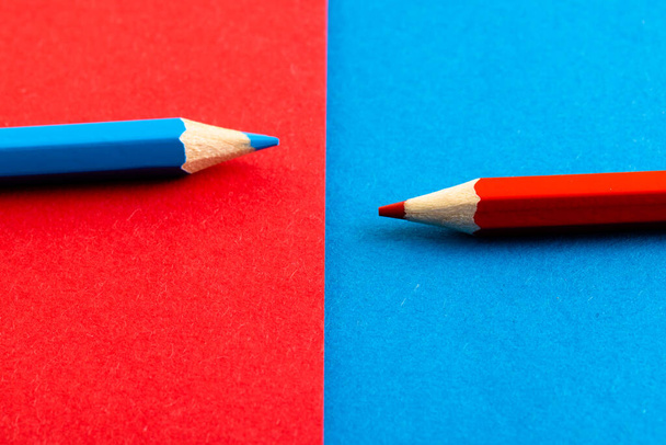 Close up of red and blue pencils with copy space on red and blue background. School materials, writing, colouring, drawing, learning, school and education concept. - Фото, зображення