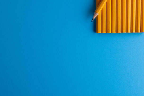 Close up of yellow pencils and copy space on blue background. Writing, drawing, learning, school and education concept. - Foto, imagen