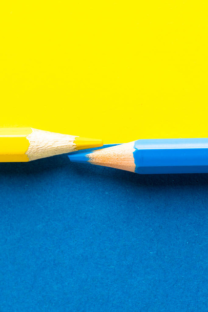 Close up of yellow and blue pencils with copy space on yellow and blue background. School materials, writing, colouring, drawing, learning, school and education concept. - 写真・画像