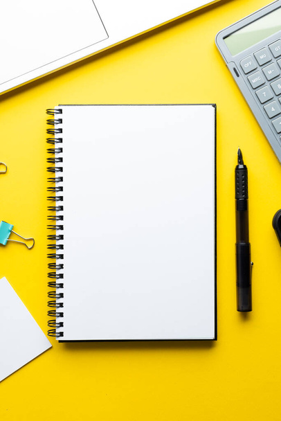 Flat lay of notebook with copy space and school materials on yellow background. School materials, writing, colouring, drawing, learning, school and education concept. - Foto, Imagen