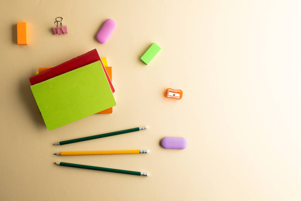Flat lay of pencils, memo notes, sharpener and erasers with copy space on yellow background. School materials, writing, colouring, drawing, learning, school and education concept. - Foto, Imagen