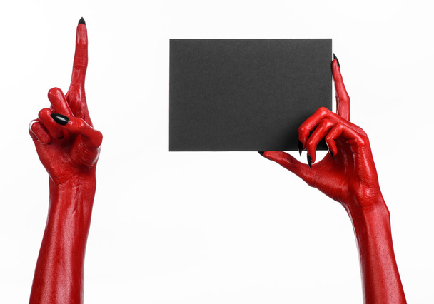 Halloween theme: Red devil hand with black nails holding a blank black card on a white background - Photo, Image