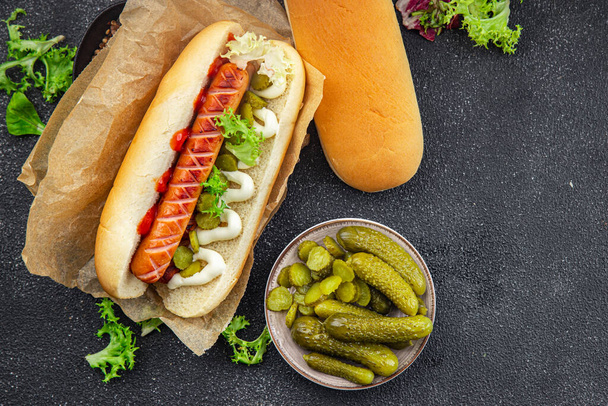 hot dog fast food σάντουιτς λουκάνικο, gherkin, κέτσαπ, μαγιονέζα γεύμα σνακ τροφίμων στο τραπέζι αντίγραφο χώρο τροφίμων φόντο ρουστίκ πάνω όψη - Φωτογραφία, εικόνα