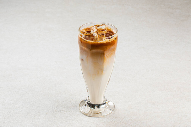 アイスとミルク入りの冷たいコーヒーのグラスを背景に - 写真・画像