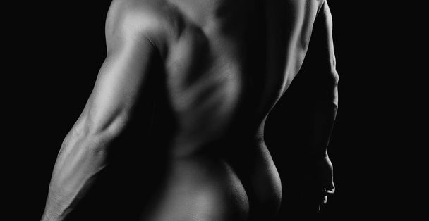 Manliness booty. Muscular back. Fashion brutal guy with sexy naked torso. Muscular model man on dark background - Фото, зображення