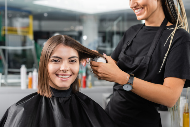 サロンサービス,女性の顧客のラウンドブラシスタイリングの髪を持つ美容師,短い髪を持つ幸せなブルネットの女性,美容室,ボリューム,髪の専門家  - 写真・画像