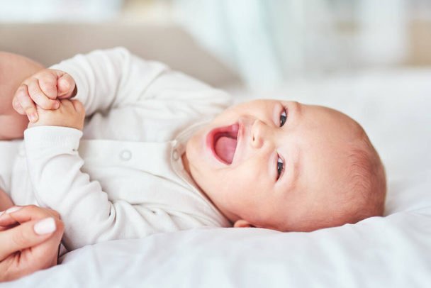 Laugh, portrait and a baby on the bed with mother for play, bonding and wake up in the morning. Smile, house and a little newborn child in the bedroom for happiness, care and together with mom. - Foto, Bild