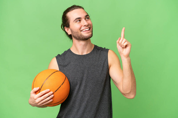 Fiatal kosárlabda játékos férfi elszigetelt háttér rámutatva egy nagyszerű ötlet - Fotó, kép