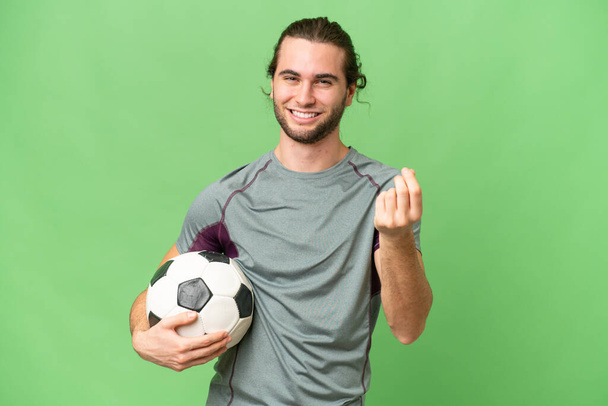 Νεαρός όμορφος ποδοσφαιριστής πάνω από απομονωμένο υπόβαθρο κάνοντας χειρονομία χρήματα - Φωτογραφία, εικόνα