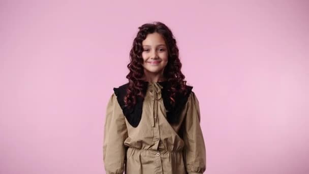 4k-Video eines jungen Mädchens, das zustimmt und seinen Kopf über rosa Hintergrund nickt. Konzept der Emotionen. - Filmmaterial, Video