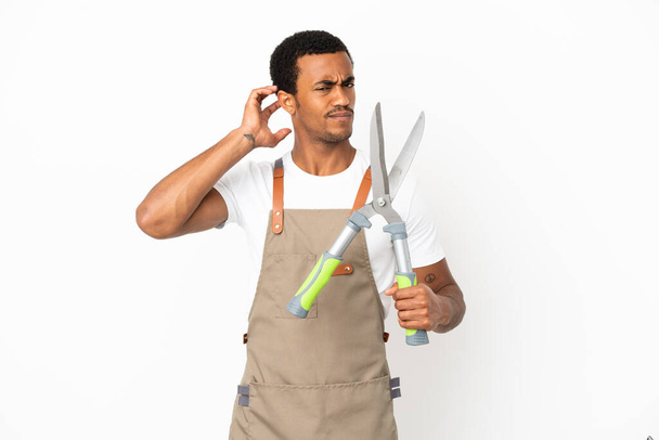 Чоловік афроамериканського садівника, який обрізає ножиці через ізольоване біле походження, сумнівається - Фото, зображення
