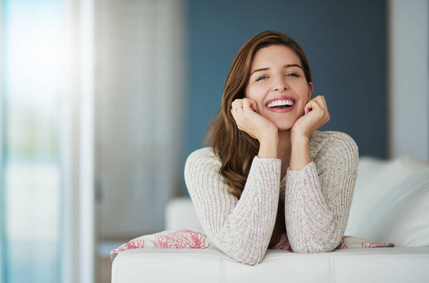 Portrait, happy and woman relax on sofa in home living room laughing at comedy. Face, smile or excited female person from Canada on couch in lounge, apartment or house to enjoy me time, joke or funny. - Photo, image