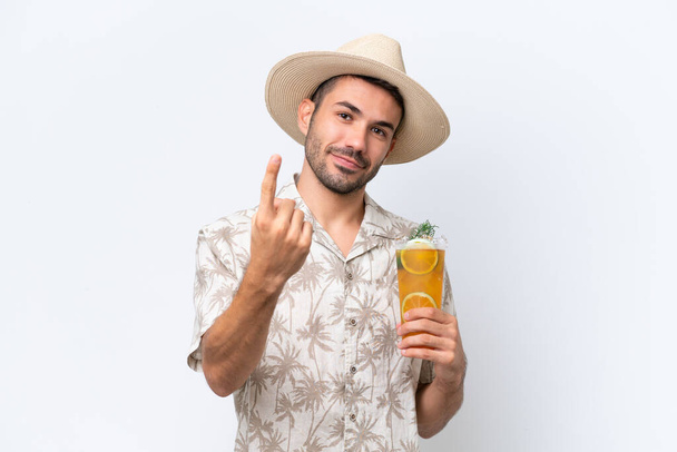 Giovane uomo caucasico in possesso di un cocktail isolato su sfondo bianco facendo gesto imminente - Foto, immagini