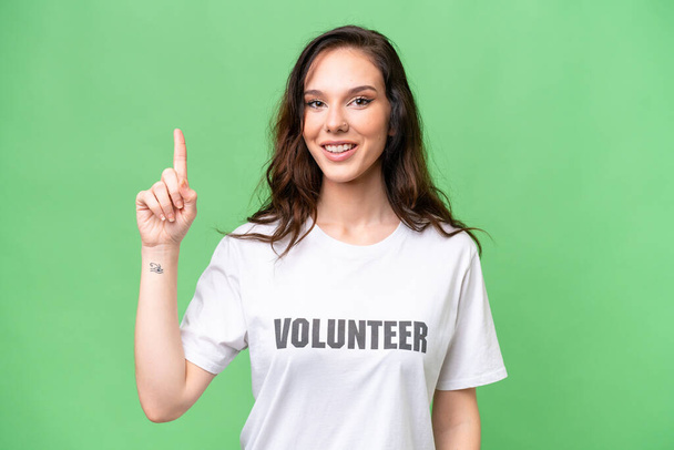 Giovane volontario donna caucasica su sfondo isolato che indica una grande idea - Foto, immagini