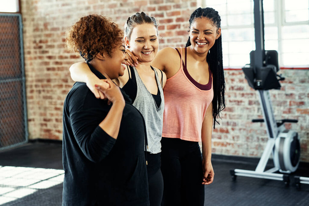Αυτό ήταν πολύ δύσκολο. τρεις χαρούμενες νεαρές γυναίκες που συζητούν ενώ κρατούν η μία την άλλη πριν από μια προπόνηση σε γυμναστήριο - Φωτογραφία, εικόνα