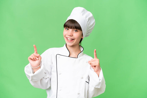 Little caucasian chef girl over isolated background pointing up a great idea - Photo, image