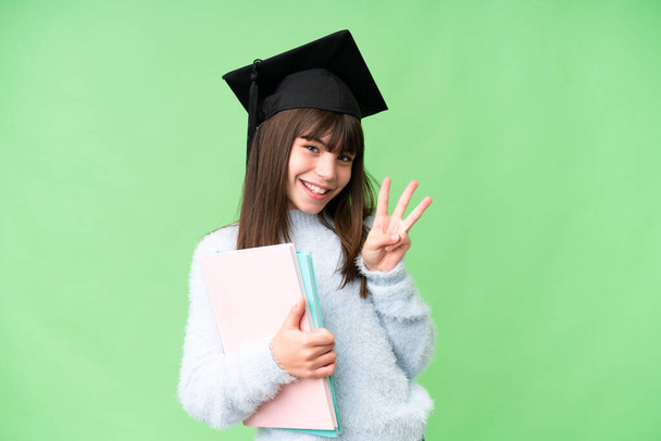 Little caucasian student girl over isolated background happy and counting three with fingers - Foto, afbeelding