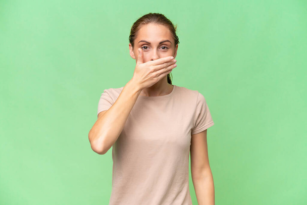 Young caucasian woman over isolated background covering mouth with hand - Foto, Bild
