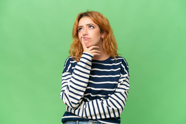Молода біла жінка ізольована на фоні ключа хроми на зеленому екрані, має сумніви під час пошуку
 - Фото, зображення