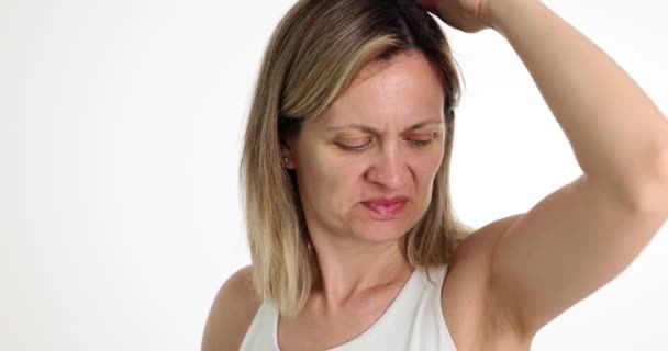 Portrait of woman sniffing armpits and disgusted by smell. Bad odor and diseases of body - Footage, Video
