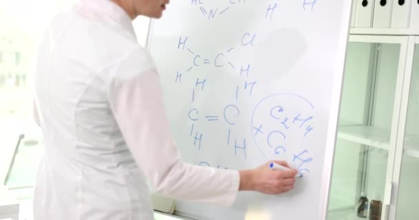 Kobieta naukowiec rysując formuły chemiczne na pokładzie. Badania chemiczne i edukacja naukowa - Materiał filmowy, wideo