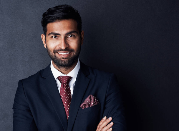 Succeeding in business with confidence and conviction. Studio shot of a confident young businessman posing against a gray background - Foto, Imagen