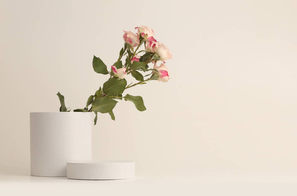 Рожевий трояндовий квітковий букет на білому подіумі. Світло-бежевий фон. Мінімальна порожня сцена презентації продукту
. - Фото, зображення