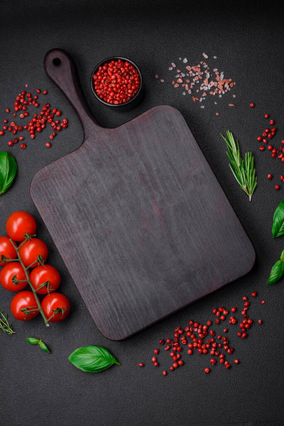 Состав для приготовления помидоров черри, соли, специй и трав на темно-бетонном фоне - Фото, изображение