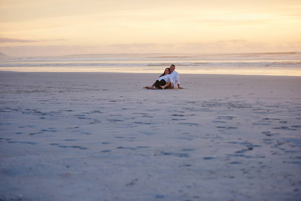 Tomando un tiempo juntos. una pareja madura relajándose juntos en la playa - Foto, imagen