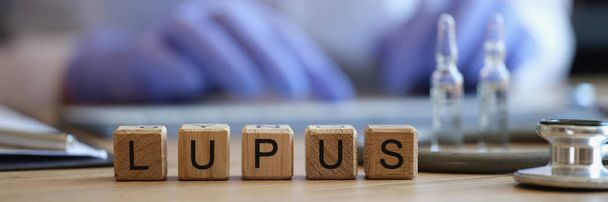 Close-up of lupus word on wooden cubes in raw. Doctor writing prescription or treatment. Healthcare and inflammation of skin diseases concept - Foto, Imagem