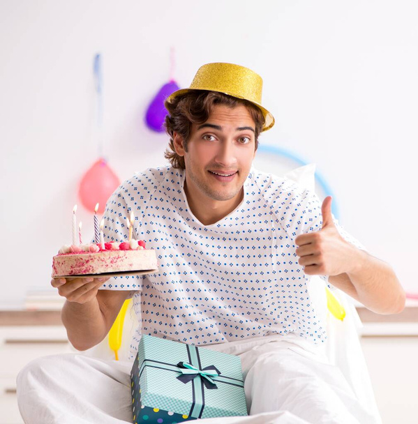 Nuori mies juhlii syntymäpäiväänsä sairaalassa. - Valokuva, kuva