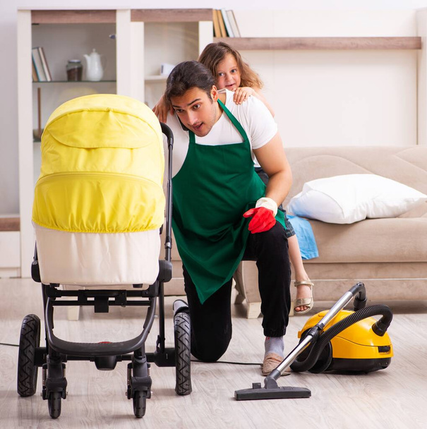 Fiatal vállalkozó takarítja a házat a kislányával. - Fotó, kép