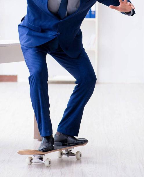 The young businessman with skate in office in sports concept - Fotografie, Obrázek