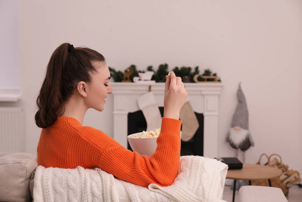 Woman with popcorn at home. Watching movie via video projector - 写真・画像