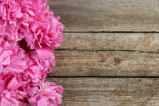 Beautiful pink peonies on wooden table, flat lay. Space for text - Foto, afbeelding