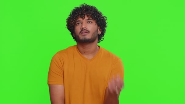 Tired bored young indian man indifferent expression, exhausted of tedious story, not interested in communication talk, displeasure, uninteresting. Hindu guy isolated on green chroma key background - Footage, Video
