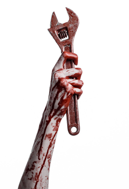 Halloween theme: bloody hand holding a big wrench on a white background - Φωτογραφία, εικόνα