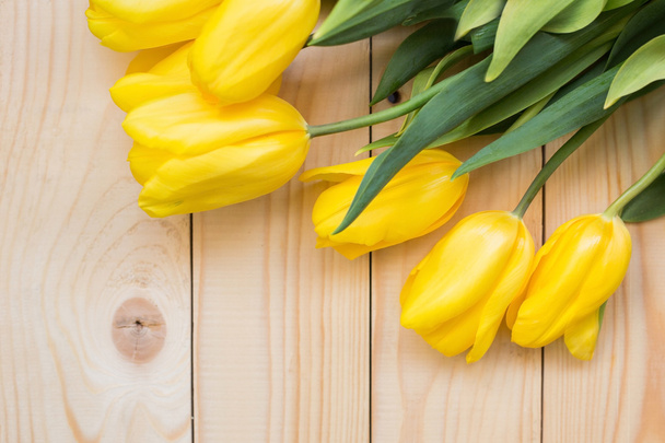 Beautiful yellow tulips on wooden background - Photo, image