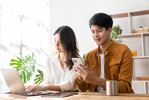 Business couple and successful business asian woman work together in the morning with laptop and paperwork discussing home finances. - Foto, Imagem