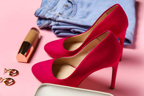 Stylish heels, clothes, earrings and liquid foundation on pink background, closeup - Фото, зображення