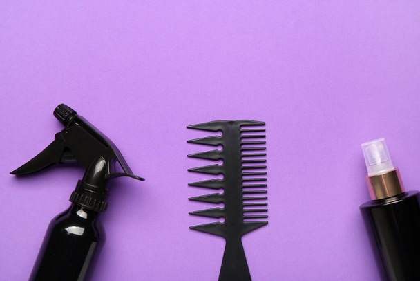 Hair brush with sprays on violet background, closeup - Foto, imagen