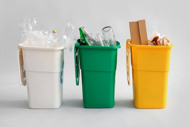 Containers with different types of garbage on light background. Recycling concept - Fotoğraf, Görsel