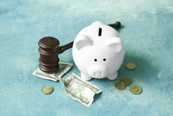 Piggy bank with judge gavel and money on grunge blue background. Concept of bankruptcy - Foto, Imagen
