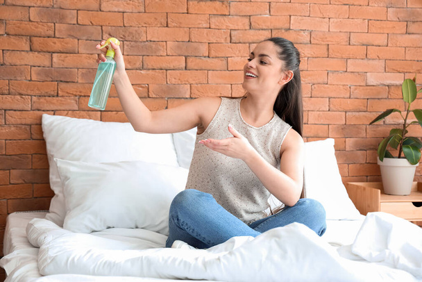 Giovane donna con deodorante in camera da letto - Foto, immagini