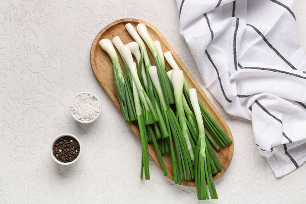 Board with fresh green onion and peppercorn on white background - Fotó, kép