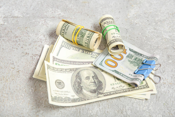 Plastik bantlı 100 dolarlık banknotlar ve gri grunge arka planda klasör klipsi - Fotoğraf, Görsel